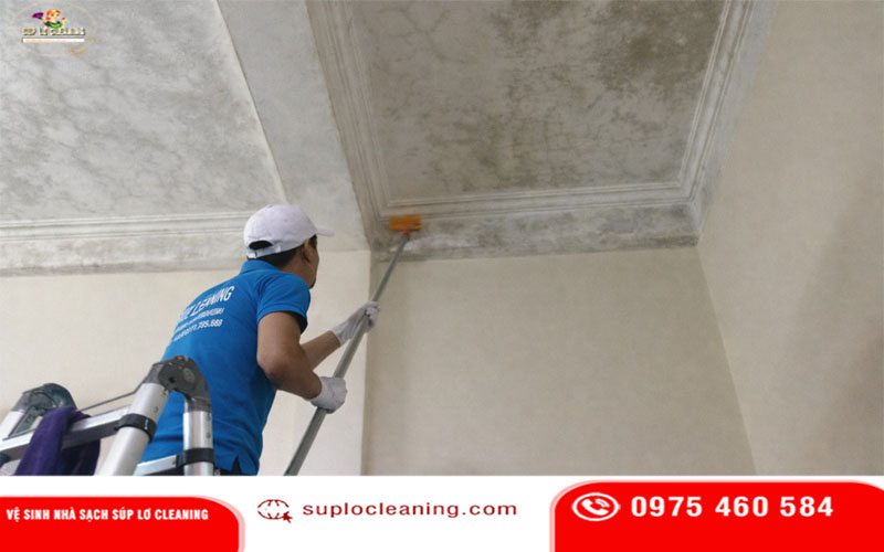 Nhân viên Súp Lơ Cleaning đang tẩy mốc tường nhà khách ở Khương Đình