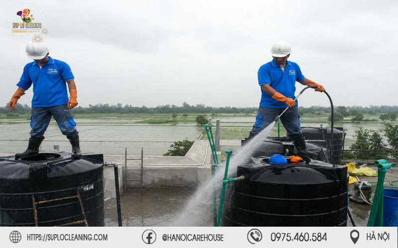 Nhân viên Súp Lơ Cleaning sử dụng vòi xịt áp lực cao làm sạch các téc nước trên mái