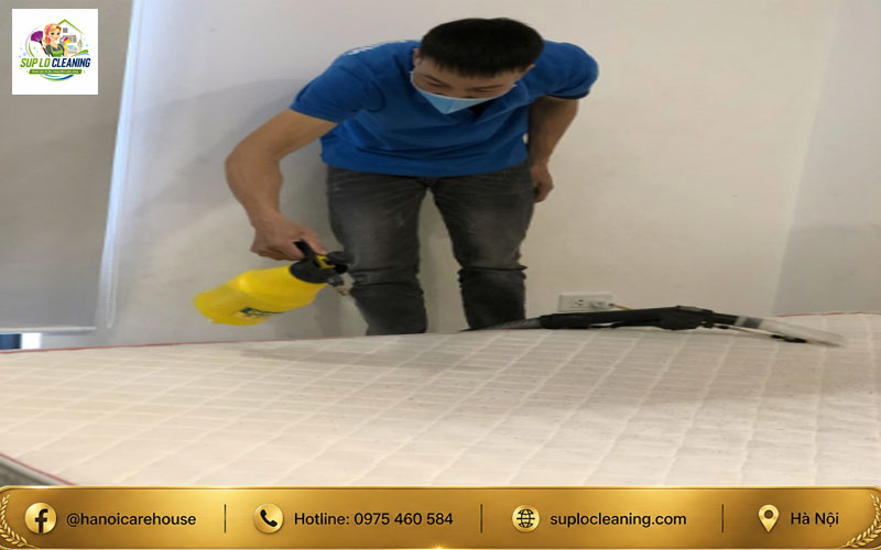Thợ kỹ thuật đang tiến hành phun dung dịch chuyên dụng khi giặt đệm tại nhà cho khách hàng